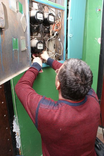 Электромонтер Алексей Кузнецов проверяет счетчик в квартире, жильцы которой тратят подозрительно мало электричества